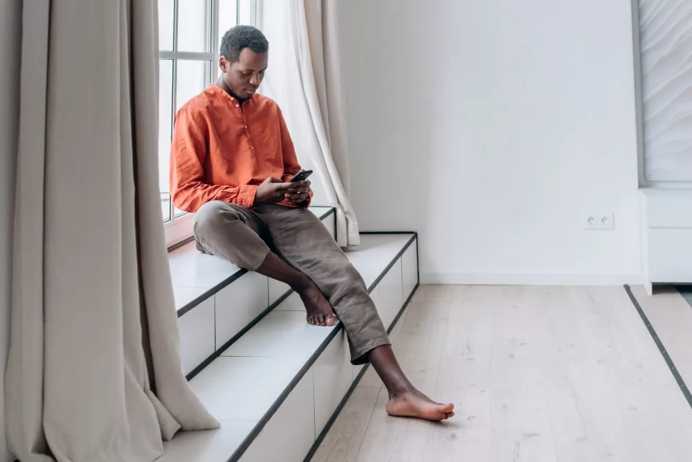 Man sitting on stairs using phone